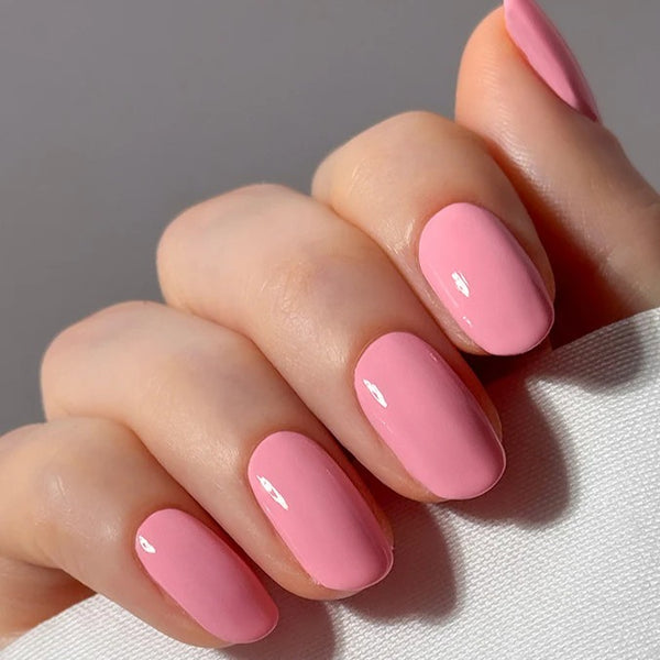 Close-up of a hand with pink nail polish on a neutral background. NAILBERRY Imperial Blush