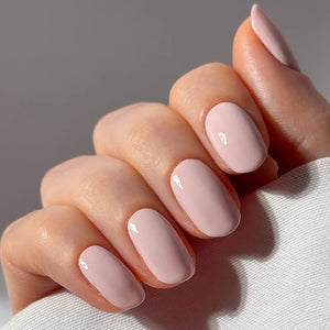 Close-up of a hand with pink nail polish on a neutral background. NAILBERRY Tokyo Spring