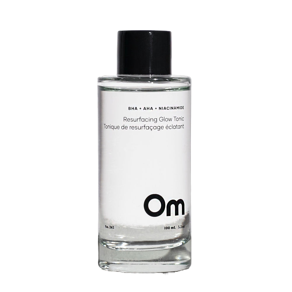 Clear bottle of Om skincare tonic with black cap on a white background