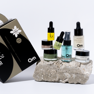 Collection of skincare products on a stone block with 'Om' branding. These are from OM ORGANICS Mini Face Care Kit for Combination Sensitive / Blemish Prone