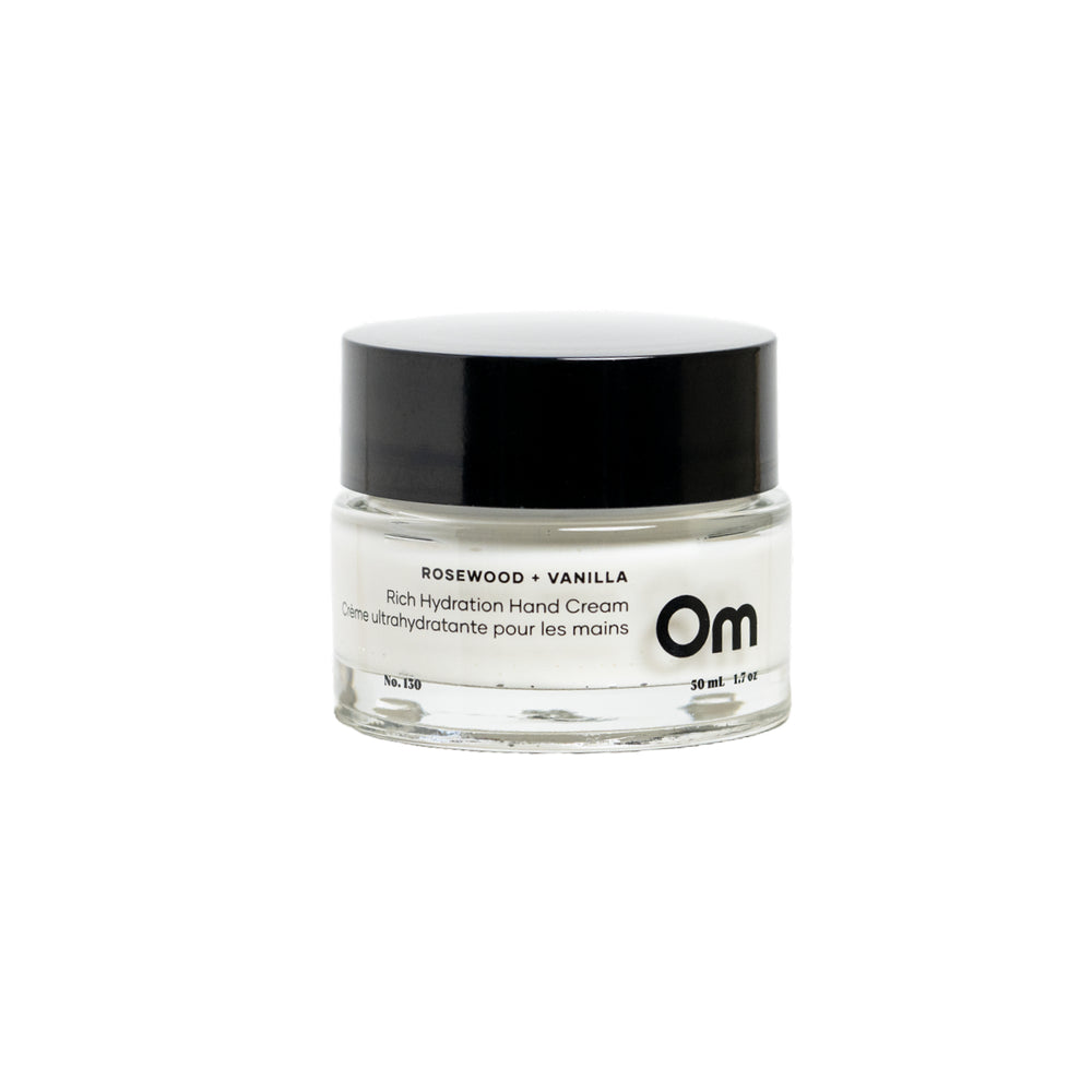 OM ORGANICS Rosewood + Vanilla Rich Hydration Hand Cream in clear glass jar with black lid on white background