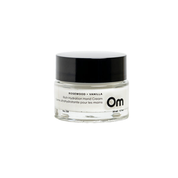 OM ORGANICS Rosewood + Vanilla Rich Hydration Hand Cream in clear glass jar with black lid on white background