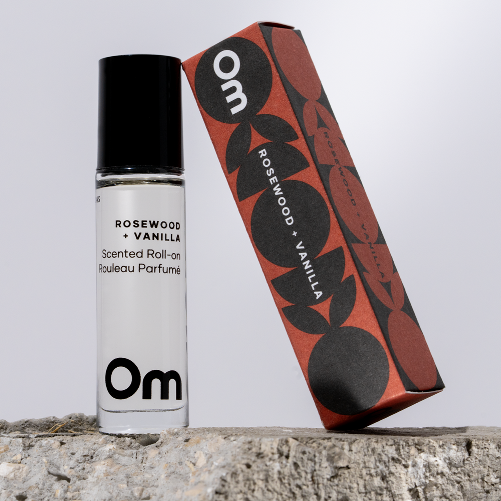 OM Organics Rosewood and Vanilla scented roll-on perfume made with organic plant-based oils and essential oils in a glass roll-on bottle.
