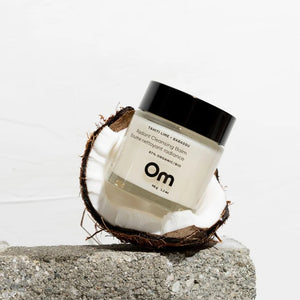 Jar of OM ORGANICS Tahiti Lime + Babassu Radiant Cleansing Balm  with coconut on a light background