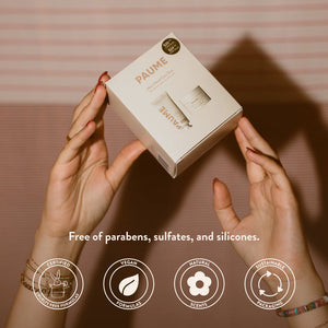 Hands holding a PAUME product box with branding and product details.