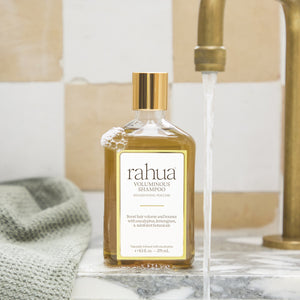 rahua voluminous shampoo bottle with running water in a bathroom setting. FULL SIZE