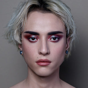 Close-up of a person with dramatic makeup and styled hair against a neutral background. RITUEL DE FILLE Celestial Sphere Gelée Eye Gloss Cygnus