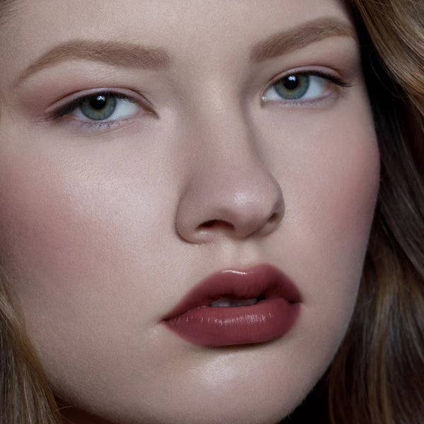 Close-up of a person's face with a focus on the lips. RITUEL DE FILLE Color Nectar Pigment Balm Weeping Cherry