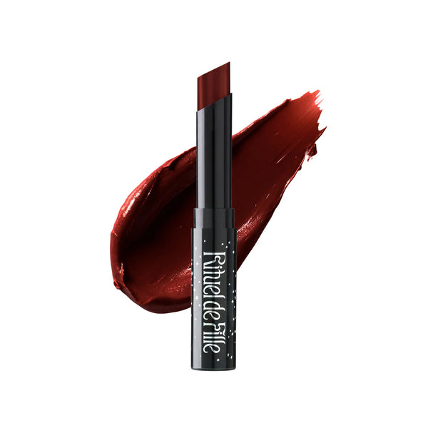 Rituel de Fille Enchanted Lip Sheer in Adder’s Tongue, a sheer bitten-blood red lipstick in a sleek black star-dusted tube with a semi-matte finish.