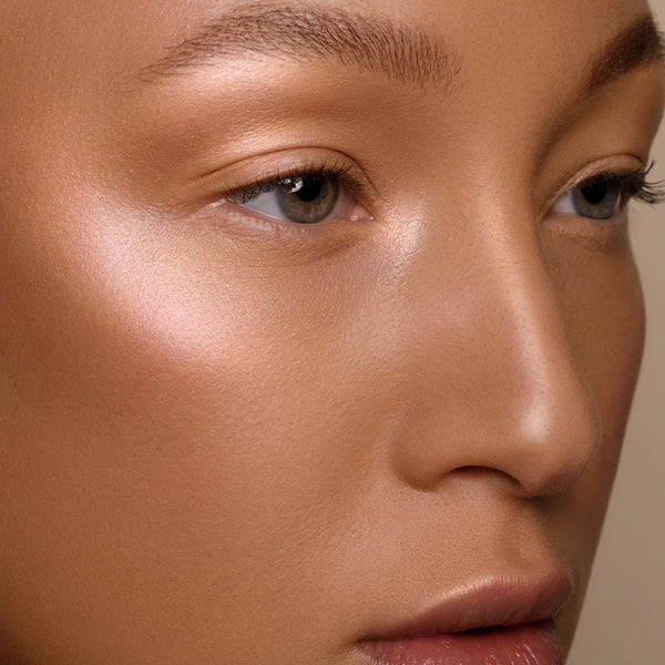 Close-up of a person's face with a neutral background. RITUEL DE FILLE Inner Glow Crème Pigment Eros