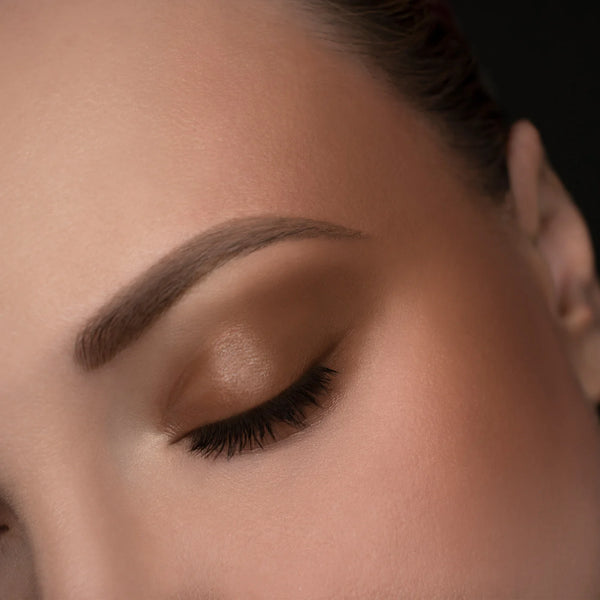 Close-up of a woman's eye with makeup on a neutral background. RITUEL DE FILLE Inner Glow Crème Pigment Eros