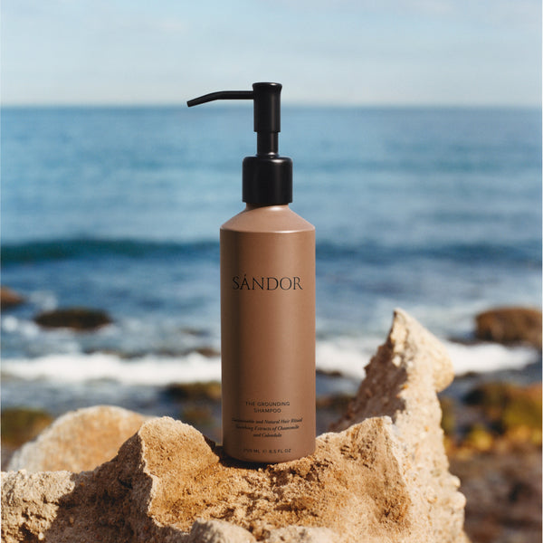SÁNDOR The Grounding Shampoo shampoo bottle with pump on a rock by the ocean ALWAYS SHOW
