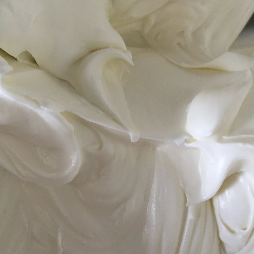 Sangre de Fruta Botanical Body Cream with a rich whipped texture, shown in black glass jar next to its packaging, on white background.