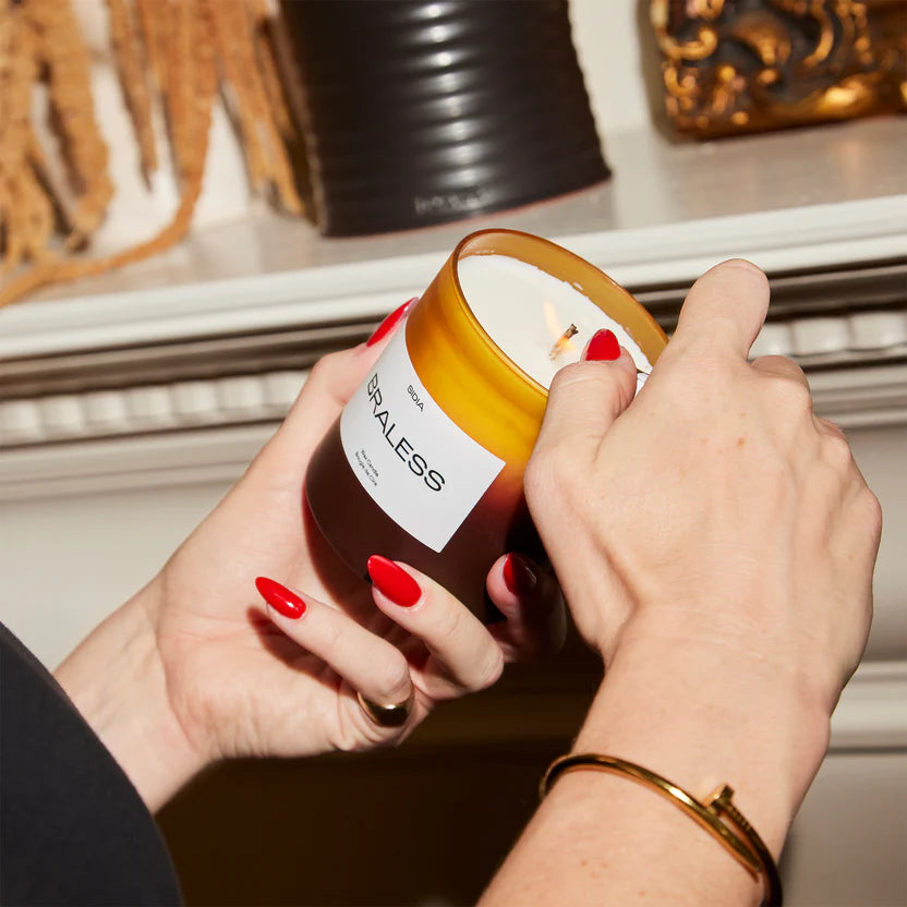 A SIDA Braless scented wax candle in a frosted amber glass jar with a white label, set against a plain white background.