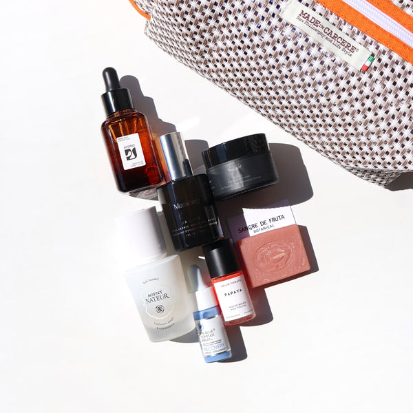 Collection of skincare products with a pouch on a white background