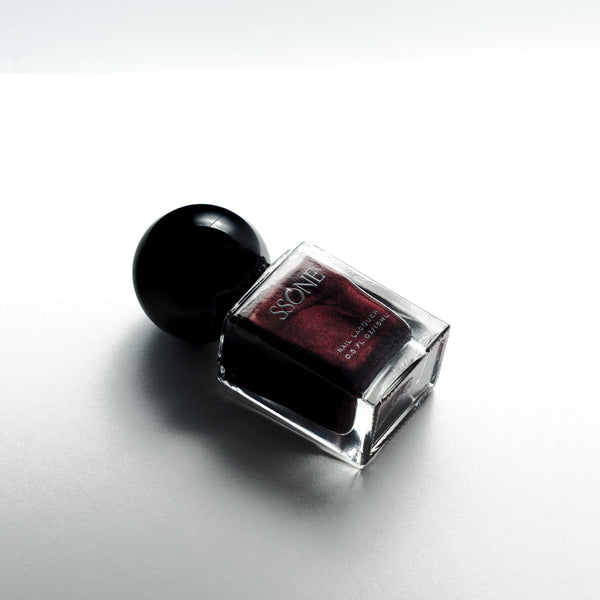 Nail polish bottle with black cap on a white background