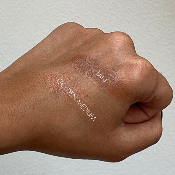 Hand swatch of 'Tan' and 'Golden Medium' makeup shades on a neutral background