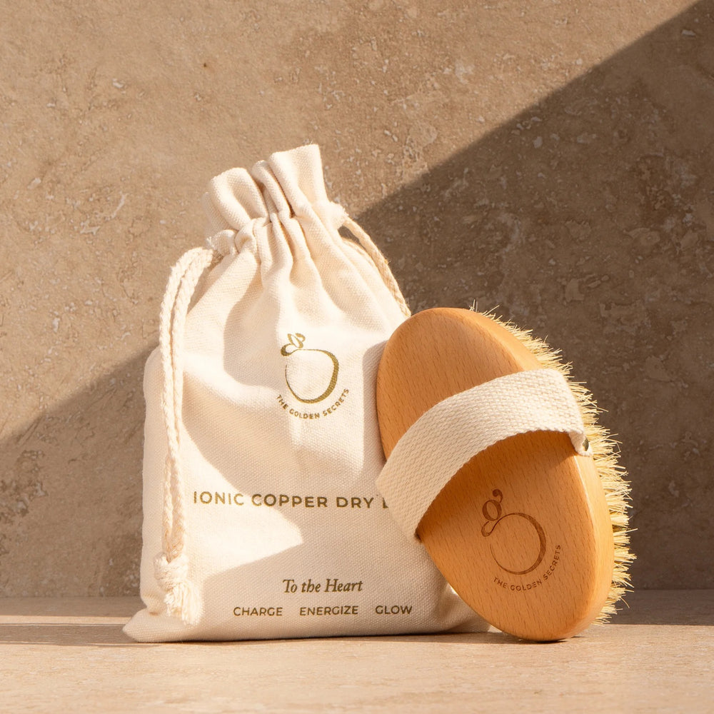 The Golden Secrets Ionic Copper Dry Brush with copper bristles and sustainable beechwood base, designed for smooth, glowing skin.