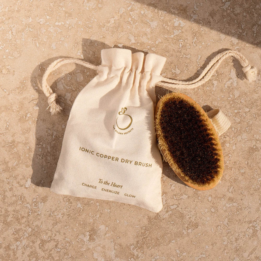 The Golden Secrets Ionic Copper Dry Brush with copper bristles and sustainable beechwood base, designed for smooth, glowing skin.