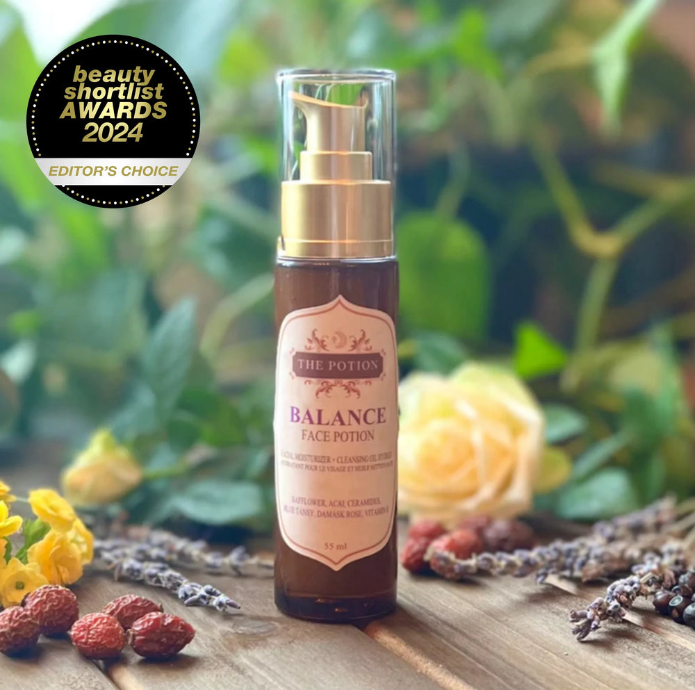 THE POTION COSMETICS Balance Facial Moisturizer + Cleansing Oil Hybrid bottle with Blue Tansy flowers, roses, and lavender, evoking a soothing spa-like skincare ritual.