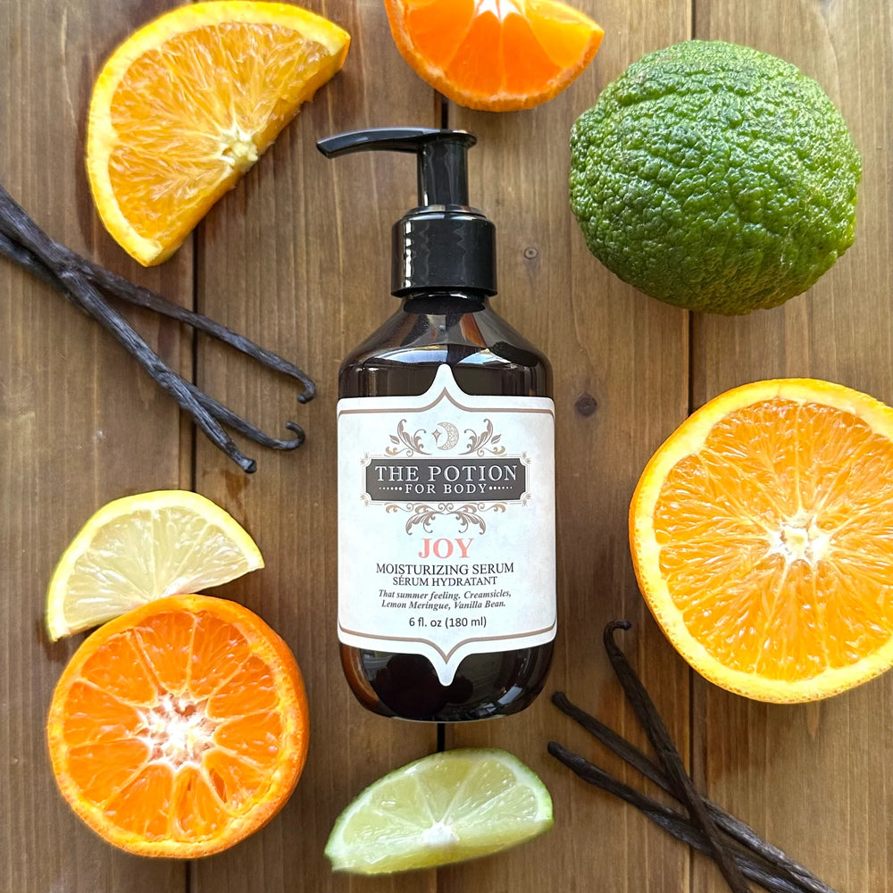 THE POTION COSMETICS Joy Moisturizing Serum bottle with citrus fruits and vanilla bean, evoking a fresh, summery glow.