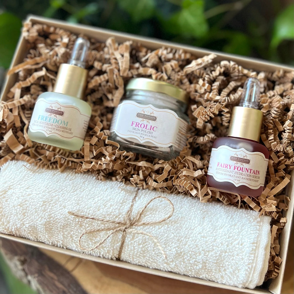 THE POTION COSMETICS The Essentials Collection featuring trial-size Freedom Face Potion, Fairy Fountain Hydration Serum, Frolic Skin Polish, and an organic cotton face cloth arranged together on a clean, minimal background.