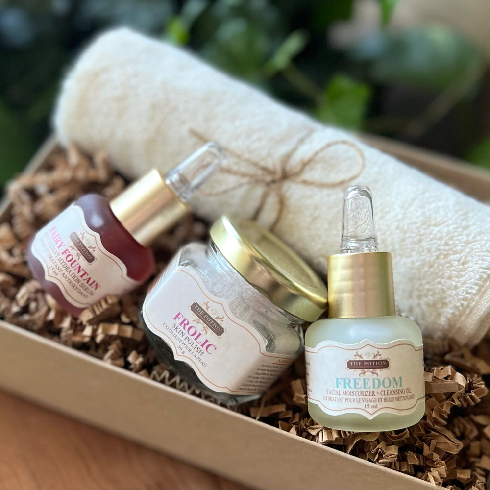 THE POTION COSMETICS The Essentials Collection featuring trial-size Freedom Face Potion, Fairy Fountain Hydration Serum, Frolic Skin Polish, and an organic cotton face cloth arranged together on a clean, minimal background.