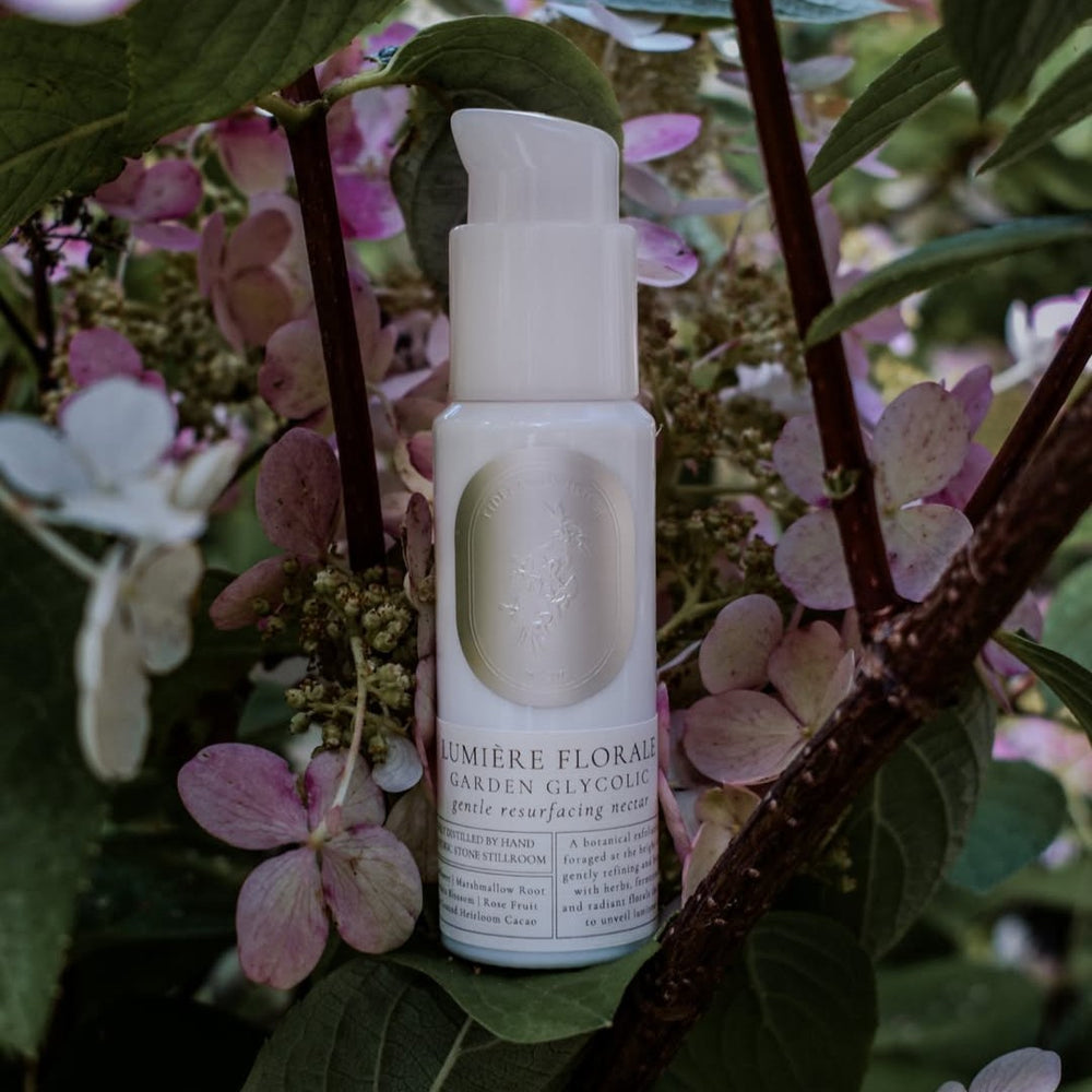 TIDELANDS HOUSE Lumiere Florale Garden Glycolic – white glass bottle of botanical resurfacing fluid with organic plant ingredients for gentle skin renewal.