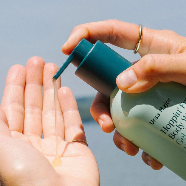 Person pumping Ursa Major body wash into their hand against a neutral background