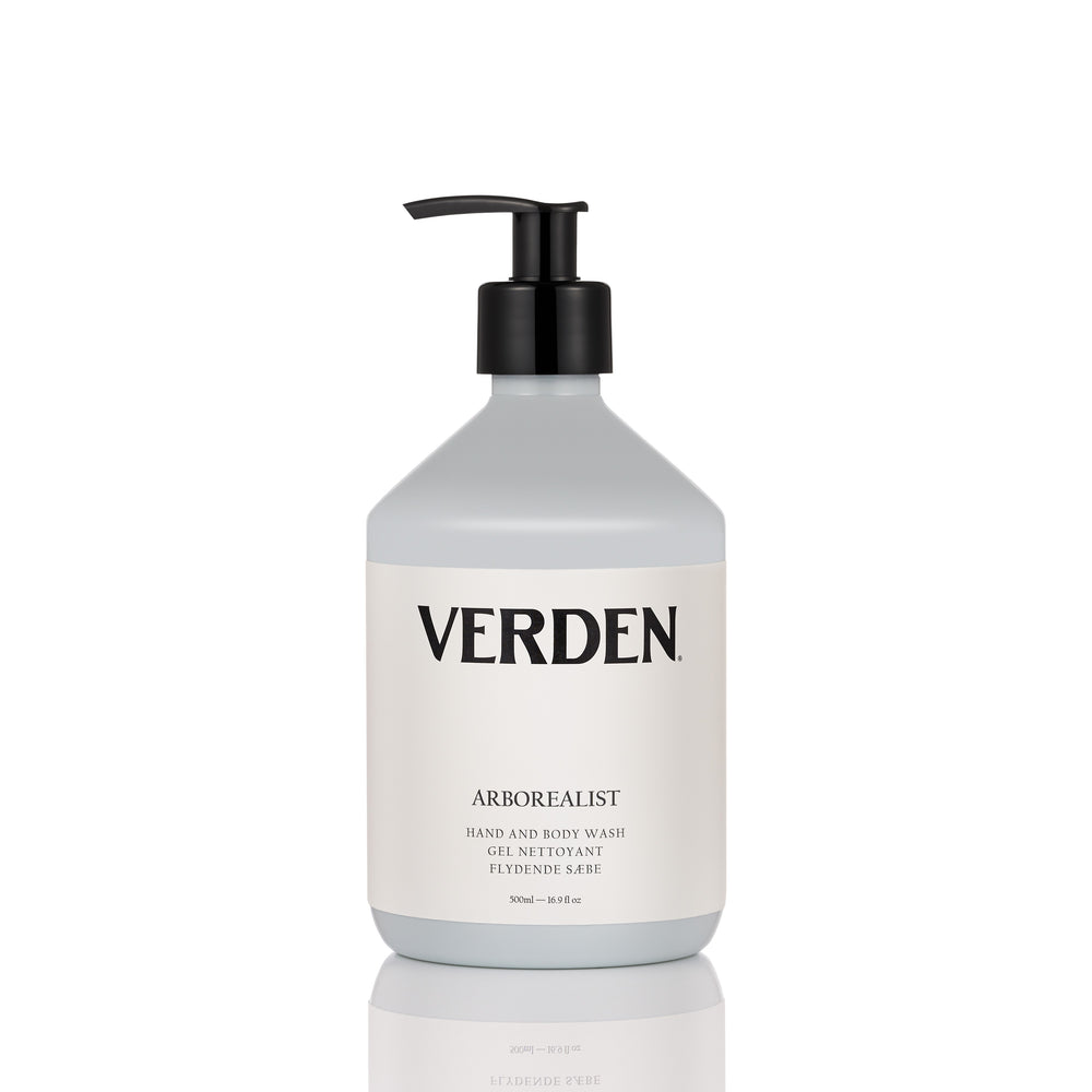 A bottle of Verden Arborealist hand and body wash with a black pump dispenser and a white label, set against a clean white background with a subtle reflection.