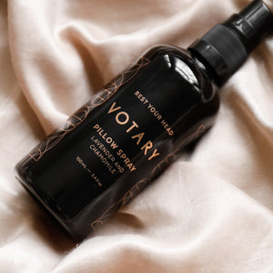 Votary pillow spray bottle on a soft fabric background