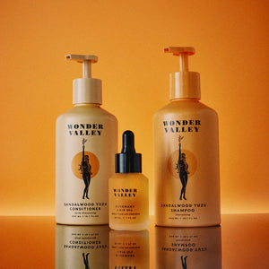 Three Wonder Valley hair care products on an orange background