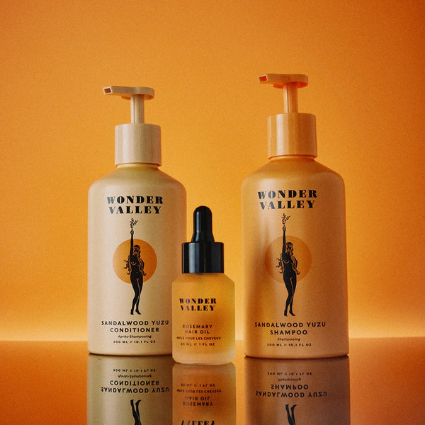 Three Wonder Valley hair care products on an orange background