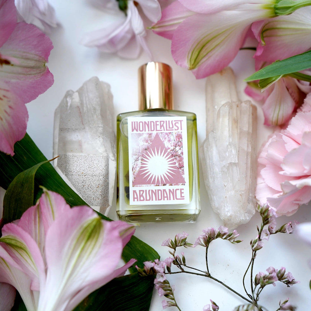 Wonderlust Botanicals Abundance Oil in a 0.5 oz roll-on bottle, featuring a blend of natural essential oils and citrine-infused grapeseed oil.