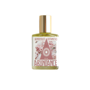 Wonderlust Botanicals Abundance Oil in a 0.5 oz roll-on bottle, featuring a blend of natural essential oils and citrine-infused grapeseed oil.
