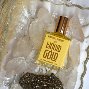 Wonderlust Botanicals Liquid Gold perfume oil, a warm and uplifting blend with lemongrass, orange, and cinnamon essential oils, in a 0.5 oz roll-on bottle.