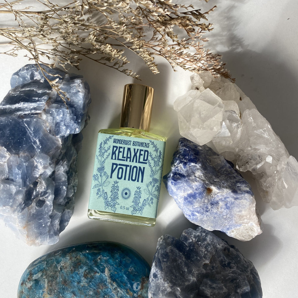 WONDERLUST BOTANICALS Relax Perfume Oil – A floral and herbaceous essential oil blend with a fresh, grounding aroma. Presented in a 0.5 oz roll-on glass bottle for easy application.