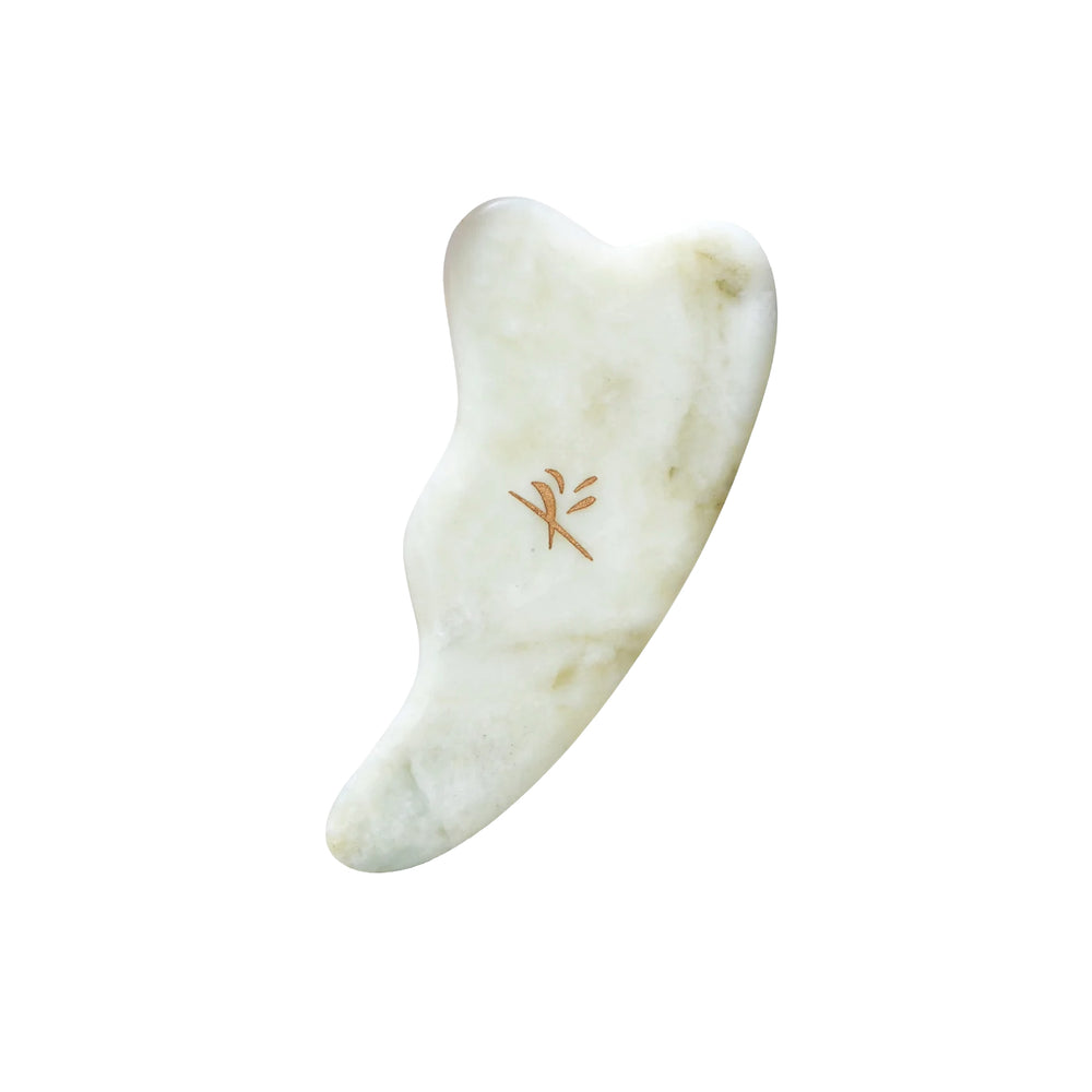 Yin Your Skin LAHJA Gua Sha Facial Tool made of green Xiuyan jade, designed with notches and curves to fit the jawline, cheekbones, and delicate eye area.